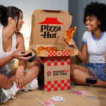 new table box from pizza hut two women enjoying pizza on the floor